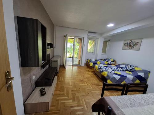 Una sala de estar con dos camas y un televisor de pantalla plana. en Ana Apartment, en Ohrid