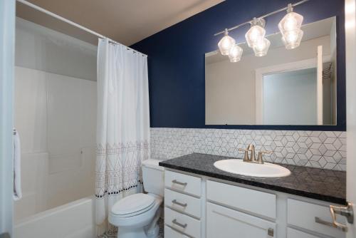 a bathroom with a sink and a toilet and a mirror at Private Hot-Tub- 3 BDR for 8 Pet's OK in Bend