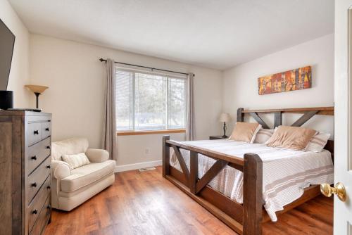 a bedroom with a bed and a chair and a window at Hot-Tub - 4BDR - Located in Eagle Crest Resort in Redmond