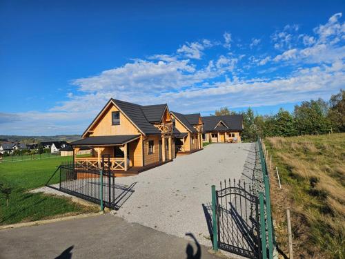 una casa con una valla al lado de una entrada en beskid.house2, en Spytkowice