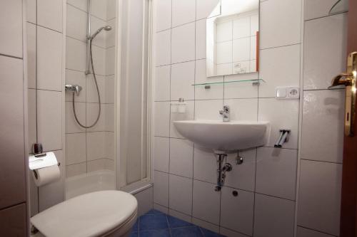 a white bathroom with a toilet and a sink at Villa Angel Dalia in Novi Vinodolski