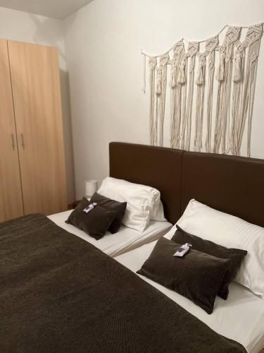 two beds in a hotel room with black and white pillows at Villa Angel Dalia in Novi Vinodolski