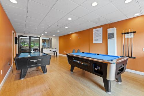 two pool tables in a room with orange walls at The Christie Lodge – All Suite Property Vail Valley/Beaver Creek in Avon