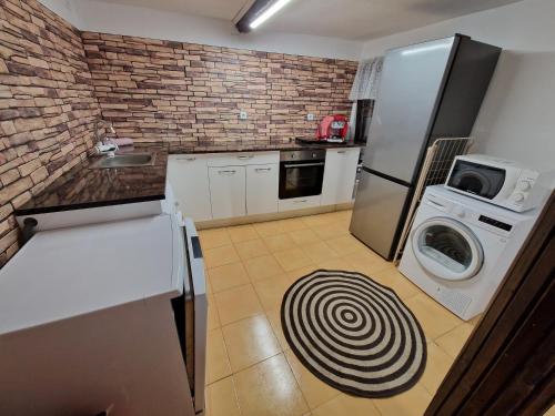 a kitchen with a refrigerator and a washer and dryer at Къщи за гости "Зелената долина" in Dalbok-Dol