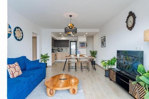 a living room with a blue couch and a table at Mombasa Road SouthPark 2 bedroom Spacious Apartments with National Park View in Nairobi