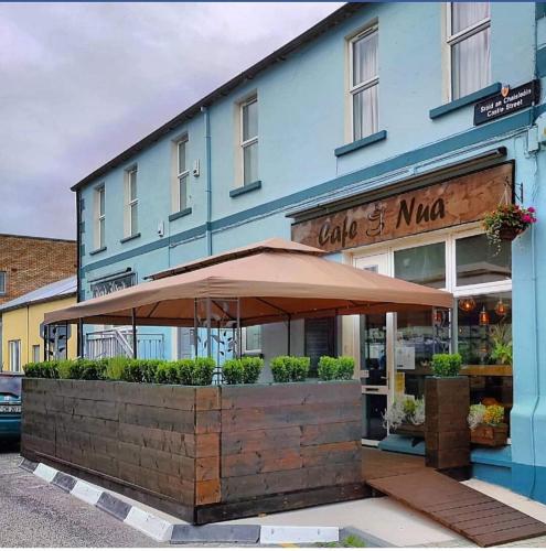 a restaurant with an umbrella in front of a building at Cois na hÉirne - Log Cabin I Lake View I Hot Tub in Belturbet