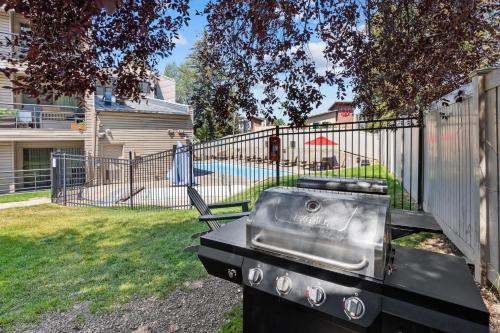 a grill in a yard next to a fence at The Christie Lodge – All Suite Property Vail Valley/Beaver Creek in Avon
