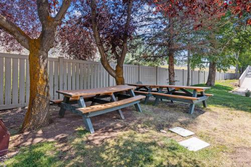 a group of picnic tables in a park with a fence at The Christie Lodge – All Suite Property Vail Valley/Beaver Creek in Avon