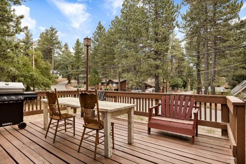 a wooden deck with a table and chairs and a grill at Pineland Getaway - Serene Escape in Green Valley Lake