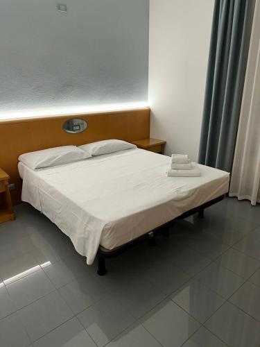 a bedroom with a bed with white sheets at Hotel La Pioppa in Bologna