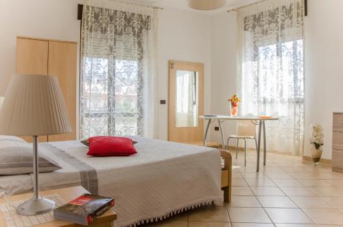 a bedroom with a bed and a table and windows at B&B Ore Liete in Martano