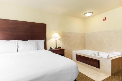 a hotel room with a bed and a bath tub at Cobblestone Hotel & Suites - Knoxville in Knoxville