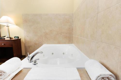 a bathroom with a bath tub and a sink at Cobblestone Hotel & Suites - Knoxville in Knoxville