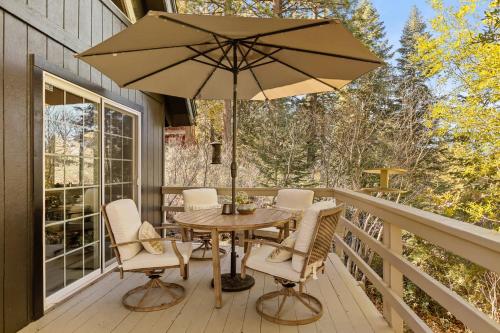 eine Terrasse mit Tisch und Stühlen und einem Sonnenschirm in der Unterkunft Chalet Vino - Snow Valley Mountain Resort in Green Valley Lake