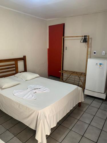 a bedroom with a bed with a white shirt on it at Hotel Santo Antoninho in Goiânia