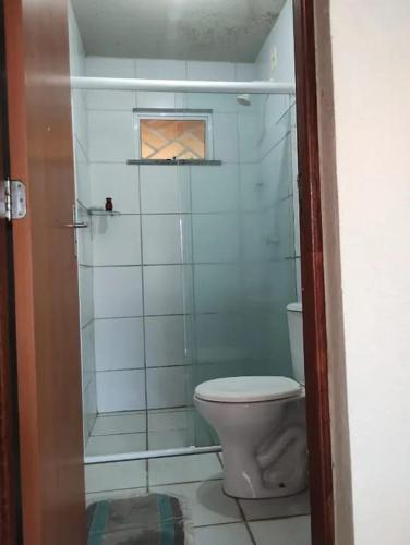a bathroom with a toilet and a glass shower at Casa Tracoá 2 in Arunta
