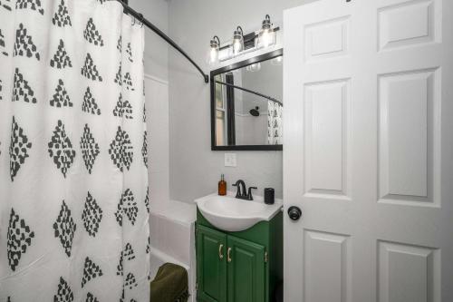a bathroom with a green cabinet and a sink at Chic Modern Gem with Style Suites in Cincinnati