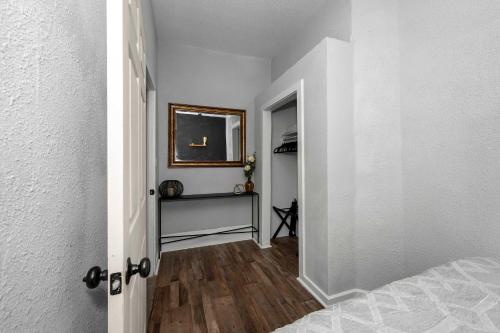 a hallway with a room with a bed and a mirror at Chic Modern Gem with Style Suites in Cincinnati