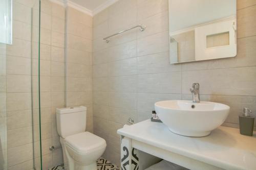a white bathroom with a sink and a toilet at AquaMarine Suites A in Kokkíni Khánion