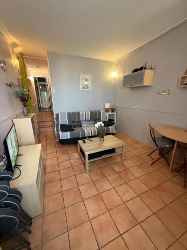 una sala de estar con un sofá y una mesa en Joli appartement climatisé bord de mer emplacement idéal, en La Ciotat