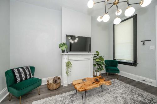 een woonkamer met 2 groene stoelen en een tafel bij Chic Modern Gem with Style in Cincinnati