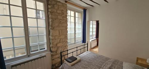 - une chambre avec un lit et un livre dans l'établissement Appartement Fontaines - Soutar Prestige, à Paris