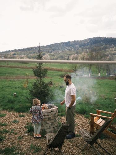 a man and a little girl standing next to a fire at Mahiya Vitriv in Staryy Sambor