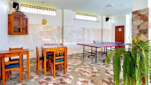 a room with two ping pong tables and chairs at Hostal Laurita Beach in Montañita
