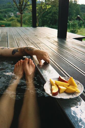 a person laying in the water with a plate of fruit at Mahiya Vitriv in Staryy Sambor