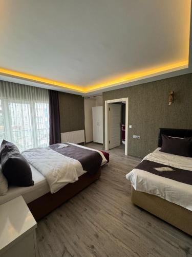 a hotel room with two beds and a hallway at De Perlas Otel in Atakum