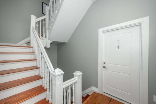 a white door in a hallway with stairs at Findlay Market Suite 3 - For 2 in Cincinnati