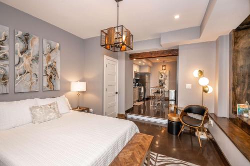 a bedroom with a white bed and a chair at Luxury Mt Adams Retreat Apt 1 in Cincinnati
