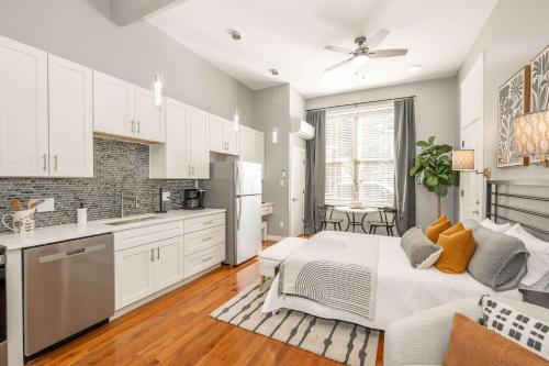a kitchen with white cabinets and a bed in a room at Findlay Market Suite 1 - For 2 in Cincinnati
