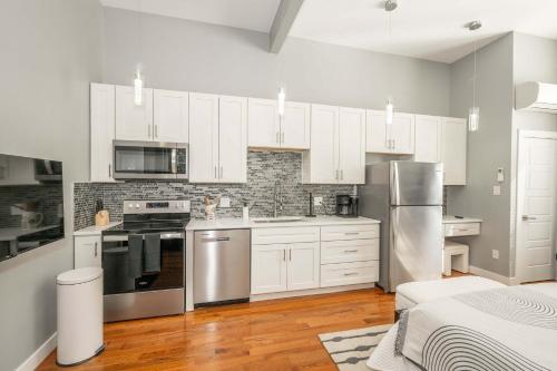 a kitchen with white cabinets and stainless steel appliances at Findlay Market Suite 1 - For 2 in Cincinnati