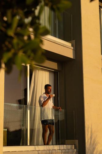 a man standing outside of a window holding a toothbrush at Metamare in Cozze