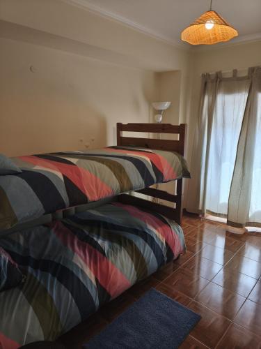 a bedroom with a bed with a striped comforter at Casa da Praça - Obidos Country Residence in Amoreira