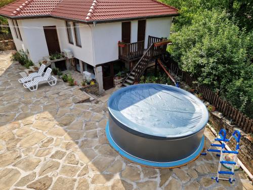 a backyard with a large blue tub and a house at Къщи за гости "Зелената долина" in Dalbok-Dol