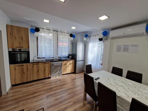 a kitchen and dining room with a table and blue balloons at Къщи за гости "Зелената долина" in Dalbok-Dol