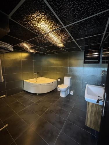 a bathroom with a tub and a toilet and a sink at De Perlas Otel in Atakum