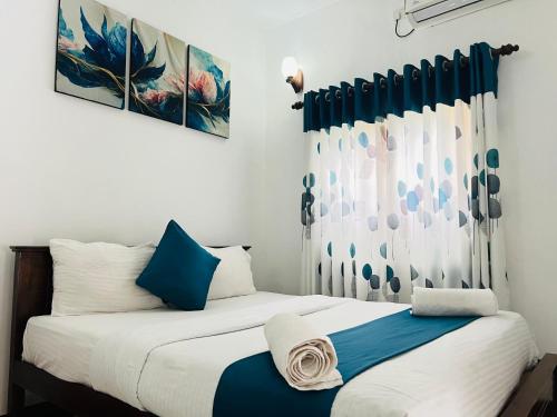 2 letti in una camera con blu e bianco di Heaven Breeze a Kandy