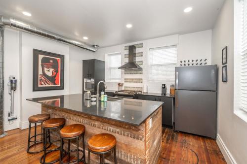a kitchen with a counter with stools and a refrigerator at City Sanctuary in Cincinnati