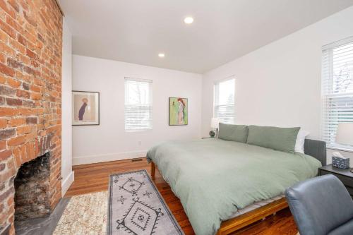 a bedroom with a bed and a brick fireplace at City Sanctuary in Cincinnati