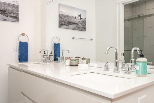 a white bathroom with a sink and two faucets at City Sanctuary in Cincinnati