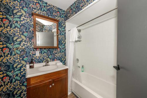 a bathroom with a sink and a shower and a mirror at Mansfield Retreat - A Chic Downtown Experience in Cincinnati
