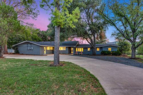a house with a tree in front of a driveway at Beach House 2 on Lake LBJ - Sleeps 24 in Kingsland