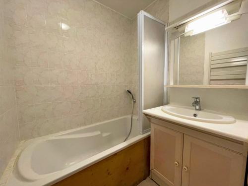une salle de bain avec une baignoire et un lavabo dans l'établissement Appartement ski aux pieds, 6 pers, balcon Sud-Ouest, animaux acceptés - Les Ménuires - FR-1-452-97, aux Menuires