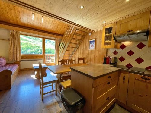 une cuisine et une salle à manger avec une table dans une cabine dans l'établissement Charmant appartement pour 6 pers. - ski aux pieds - Les Ménuires - FR-1-452-107, aux Menuires