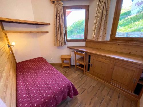 une chambre avec un lit, un bureau et une fenêtre dans l'établissement Charmant appartement pour 6 pers. - ski aux pieds - Les Ménuires - FR-1-452-107, aux Menuires