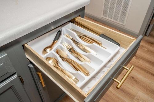 a set of gold utensils in a drawer in a kitchen at Arkstone Retreat 1 - Chic Downtown Escape in Williamstown