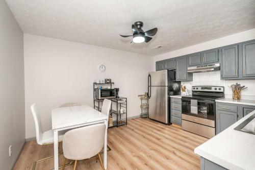 a kitchen with blue cabinets and a white table and chairs at Arkstone Retreat 1 - Chic Downtown Escape in Williamstown